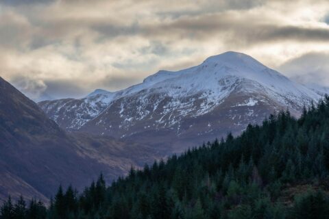 1. Majestic snowy mountain with trees and snow on top near Fort William. Things to do in Fort William, Scotland, UK