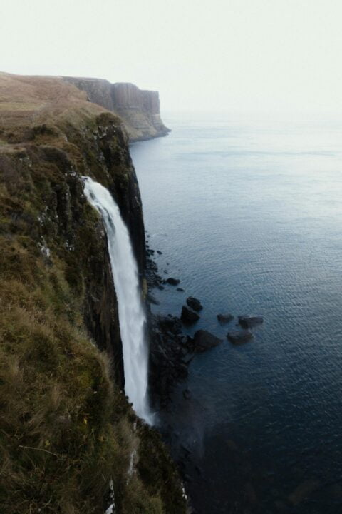 The majestic mealtfalls cascading down a towering cliff of Kilt Rock, creating a breathtaking natural spectacle.
