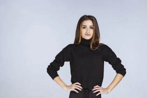A woman wearing black pants and a Long Sleeve T Shirt.