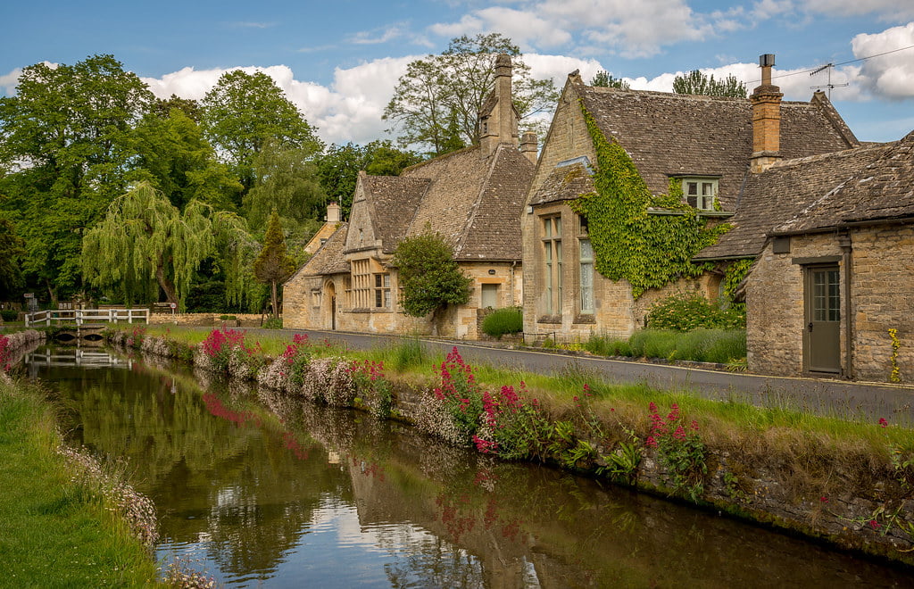A serene countryside canal with a side walk along the River Windrush and Lower Slaughter.