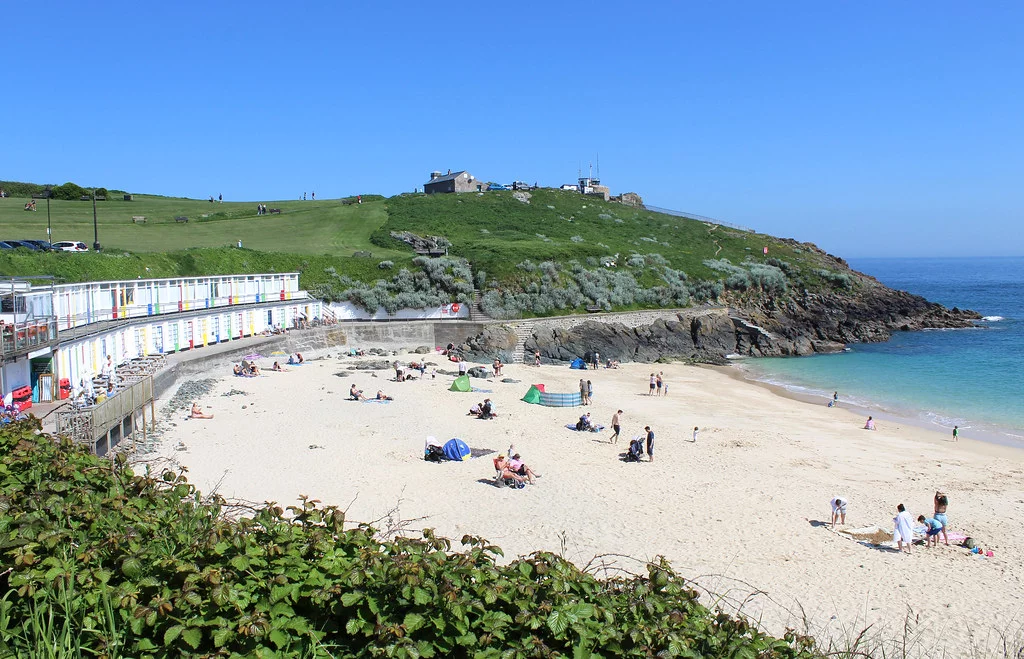 Porthgwidden Beach in St Ives, where people are having fun at the beach. Beaches in St Ives.