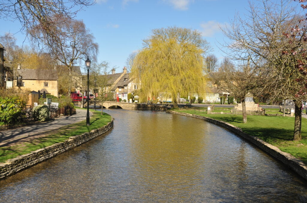 Serene River Windrush meandering peacefully through picturesque English landscape of Bourton-on-the-Water