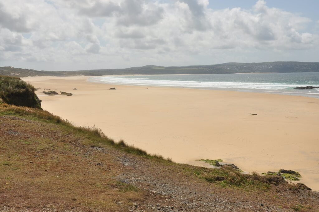Upton Towans, a serene sandy beach with crystal clear water.