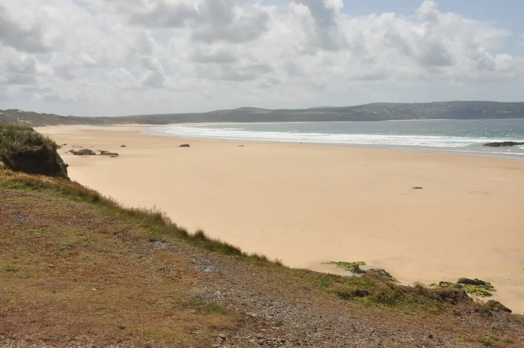 Upton Towans, a serene sandy beach with crystal clear water.