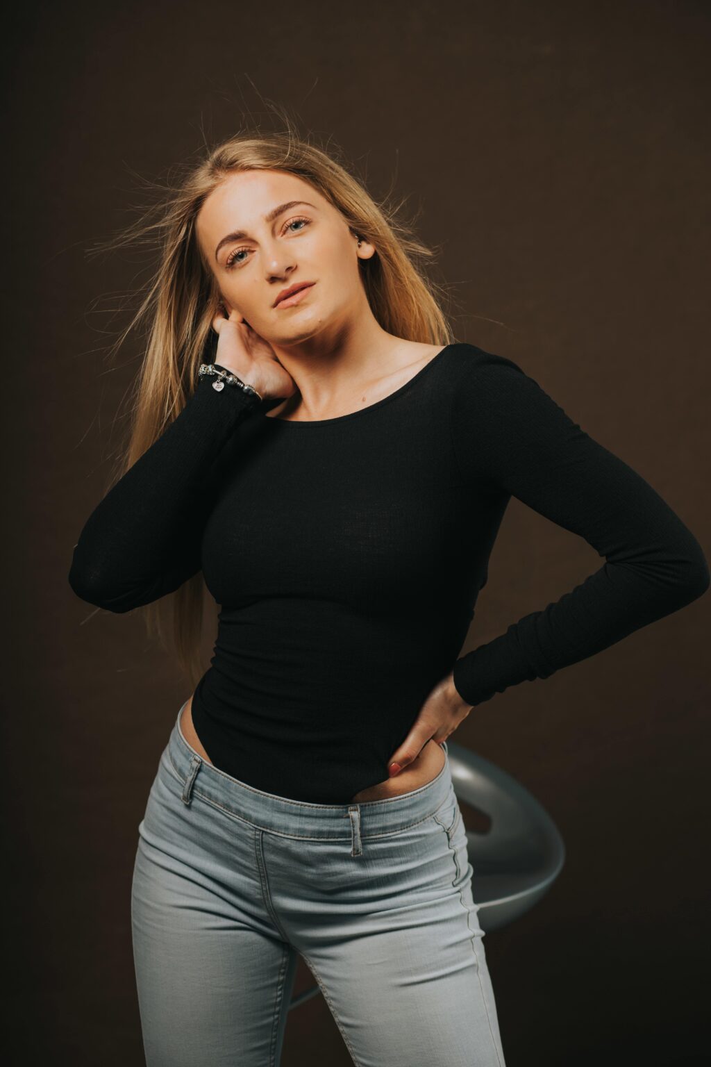 Woman wearing jeans and a well-fitted long sleeve black t shirt.