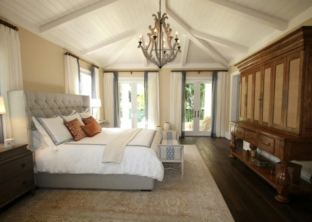 A luxurious bedroom at The Slaughters Country Inn, featuring an elegant chandelier and a comfortable bed.