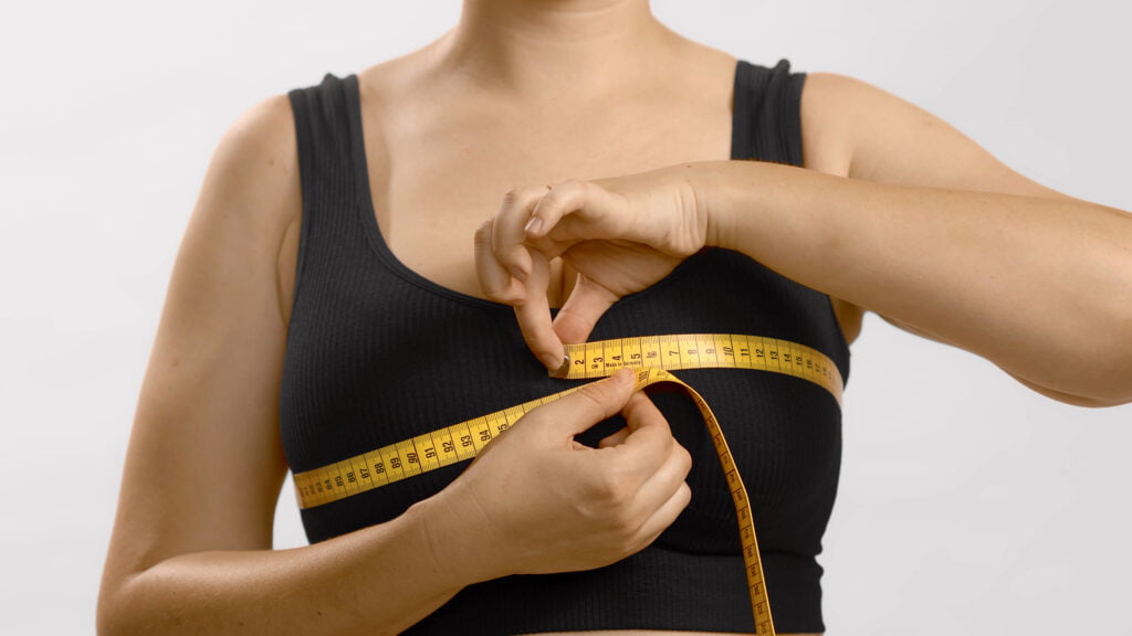 Women measuring her chest with measuring tape.