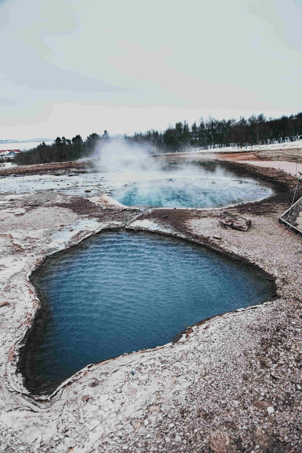 Scenic view of the geyser pool at Blesi Hot Spring's North and South Pool with steam and water.