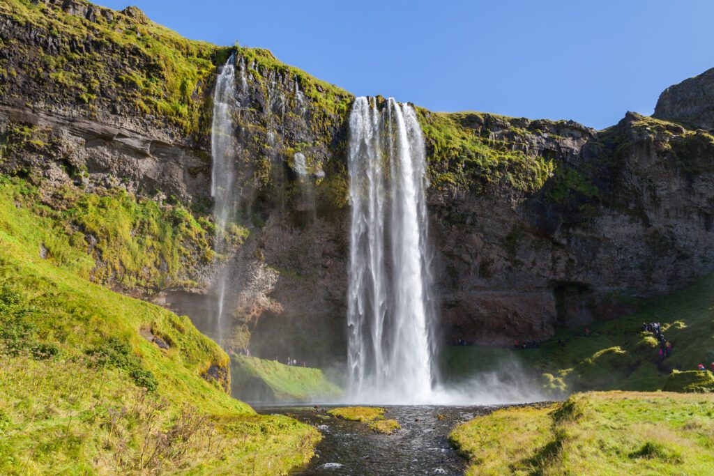 Majestic waterfall surrounded by vibrant greenery, Iceland Golden Circle.