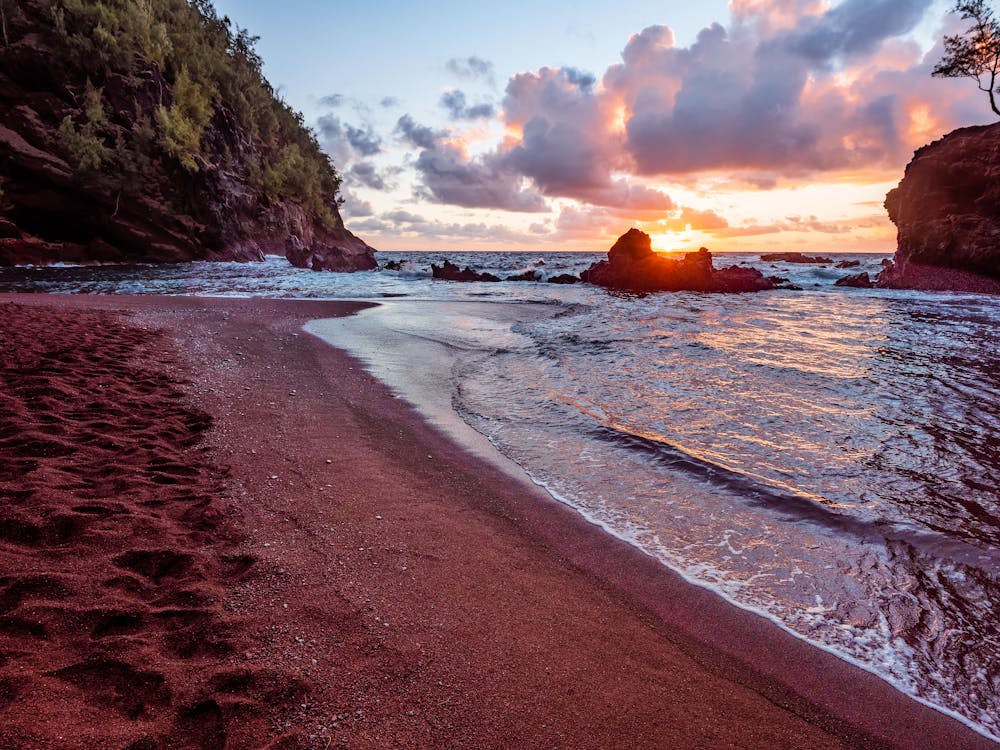 Sunset at red sand beach in Hawaii.