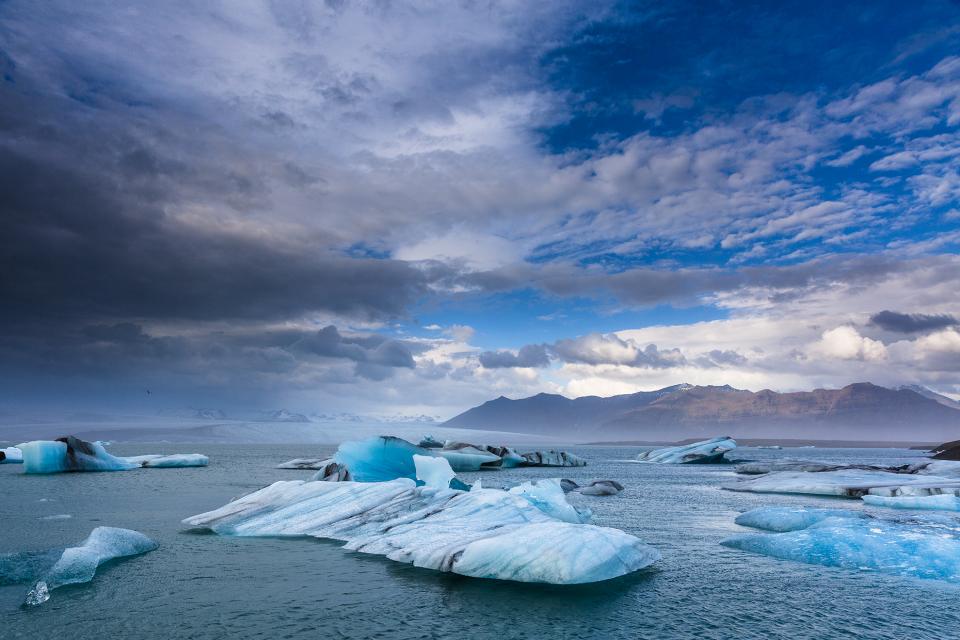 Icebergs floating in water with clouds in the sky, Iceland.
