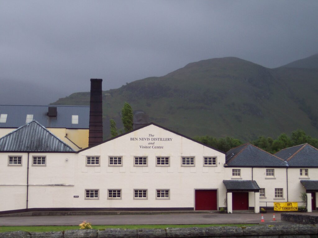 Ben Nevis Distillery stands out with its elegant building and white roof, surrounded by the beauty of the Scottish Highlands.