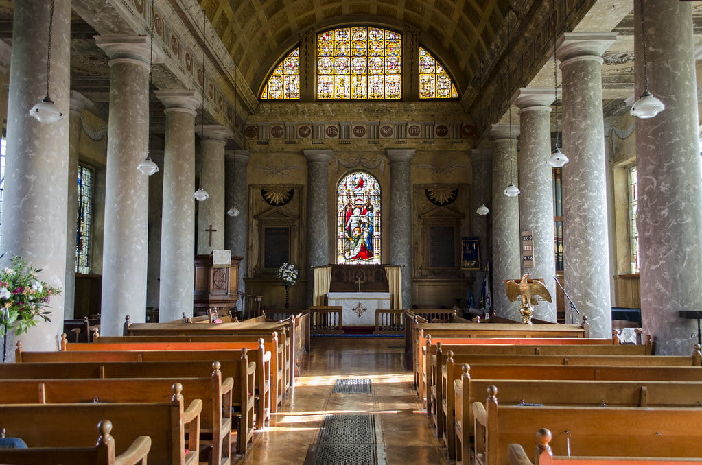 St Lawrence Church in Bourton-on-the-Water features a stunning stained glass window, illuminating the serene interior.