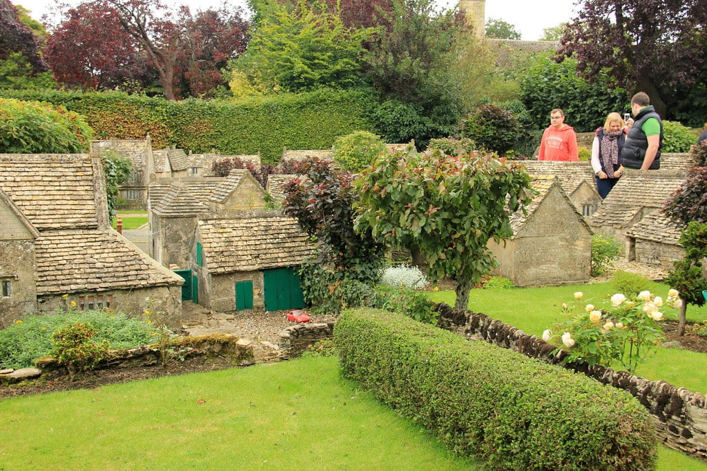 A picturesque model village in Bourton-on-the-Water, filled with miniature people walking and exploring the charming surroundings.