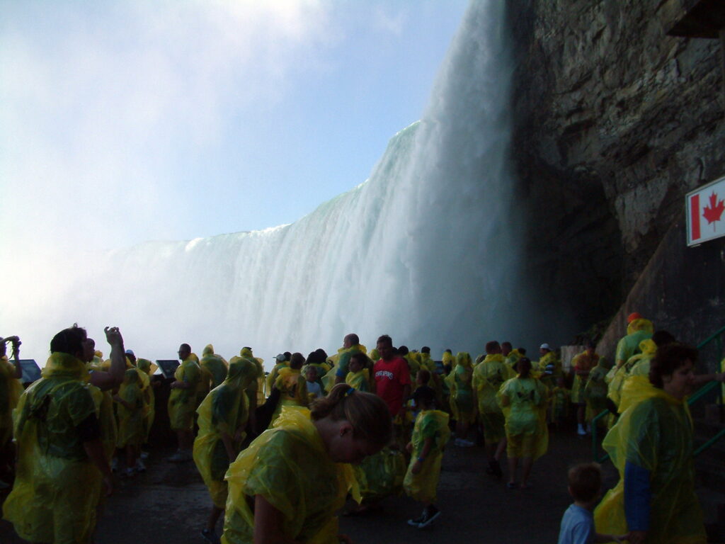 A group of people smiles in front of the majestic Niagara Falls, capturing the beauty of nature's power and splendor.