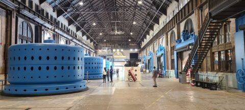 Interior view of Niagara Parks Power Station showcasing large blue pipes against a backdrop of industrial architecture.