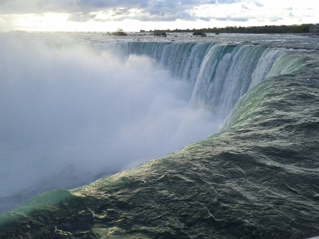 Breathtaking view from the top of Niagara Falls, showcasing the powerful cascade and lush surroundings below.