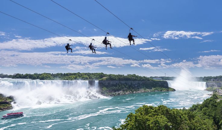 xciting view of people zip lining over the stunning Niagara Falls, experiencing the rush of nature's power from above.
